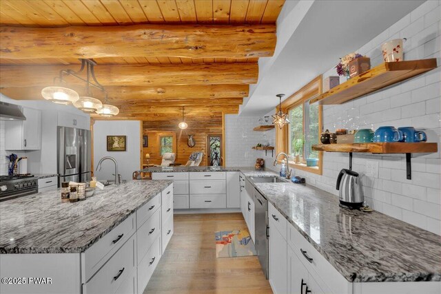 210 Fawn Lake Dr, Hawley, PA 18428 - kitchen featuring open shelves, stainless steel appliances, light wood-type flooring, white cabinetry, and log walls