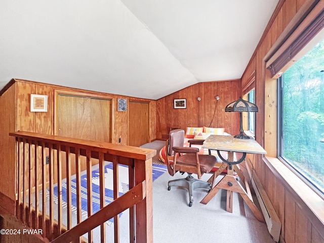 office area with carpet, vaulted ceiling, and wooden walls