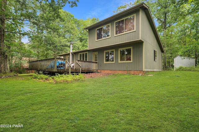 back of property featuring a lawn, a storage unit, and a wooden deck