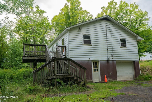 rear view of house with a deck and a garage