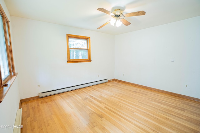 spare room with ceiling fan, a baseboard radiator, and light wood-type flooring