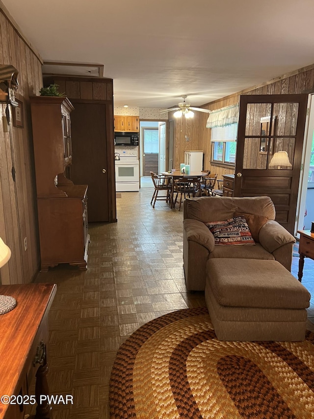 259 Florence Trl, Hawley, PA 18428 - living area featuring wooden walls, ceiling fan, and dark floors