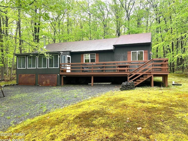 259 Florence Trl, Hawley, PA 18428 - view of front of property featuring a wooden deck, a sunroom, a wooded view, and roof with shingles