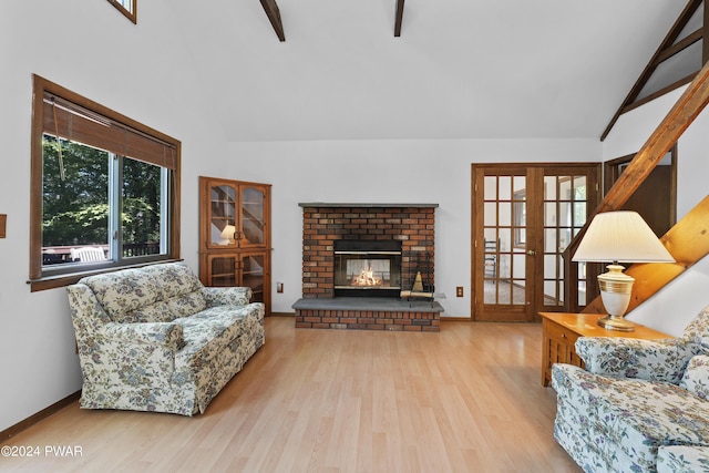 living room featuring french doors, light wood-type flooring, beam ceiling, high vaulted ceiling, and a fireplace