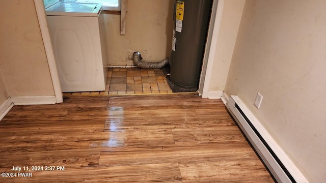 interior space featuring wood-type flooring, electric water heater, baseboard heating, and washer / clothes dryer