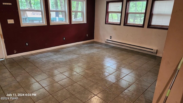 empty room featuring tile patterned floors and baseboard heating