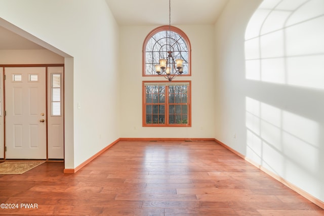 entryway with light wood-type flooring and a chandelier