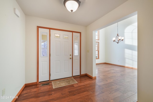 foyer with dark hardwood / wood-style floors and a notable chandelier