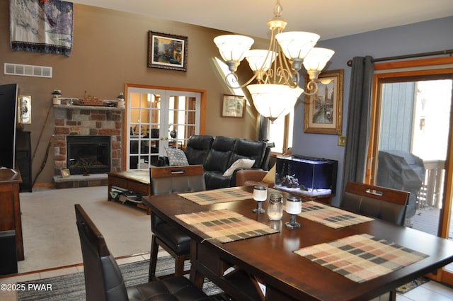 123 Fern Dr, Canadensis, PA 18325 - dining area featuring a chandelier, french doors, and a fireplace