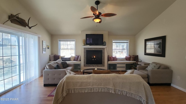 213 Powderhorn Dr, Lackawaxen, PA 18435 - living room featuring lofted ceiling, light wood-style flooring, a lit fireplace, and a ceiling fan