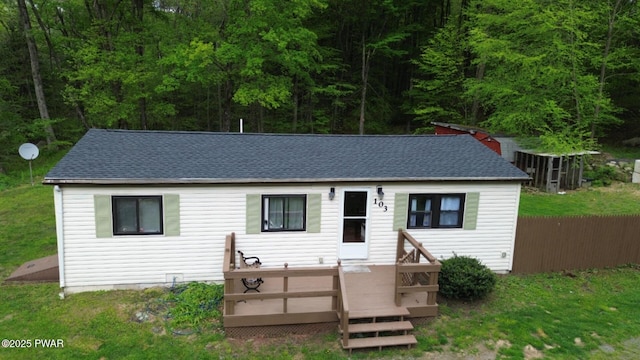 view of front of house with a shingled roof, a wooden deck, and fence
