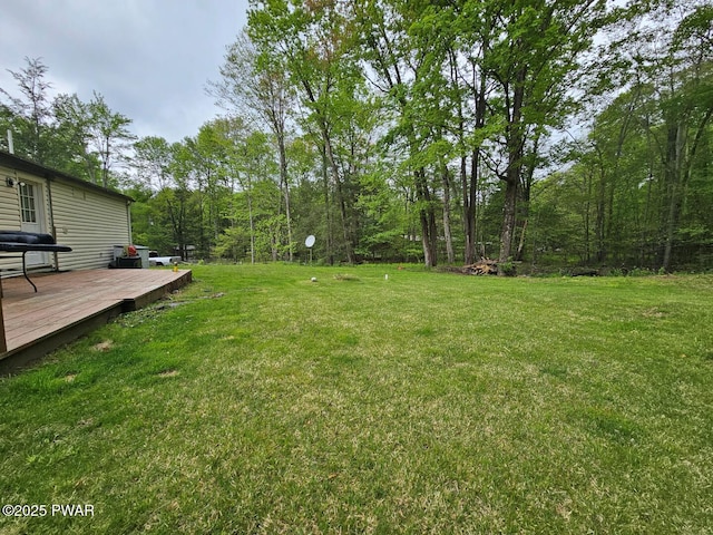 view of green lawn with a deck