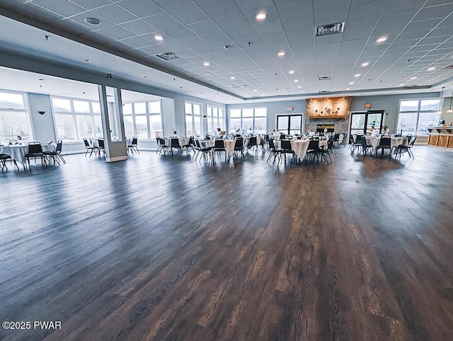 gym featuring plenty of natural light, dark hardwood / wood-style floors, and a paneled ceiling