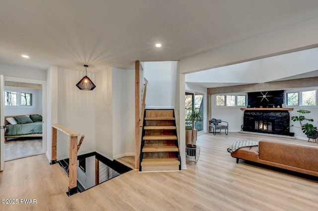 stairs featuring hardwood / wood-style flooring and a fireplace