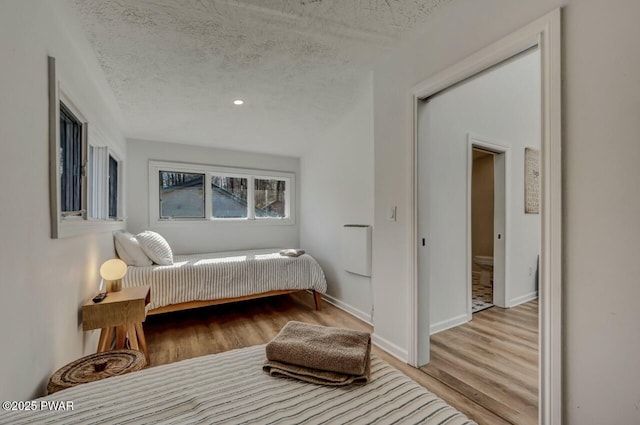 bedroom featuring a textured ceiling and light hardwood / wood-style floors