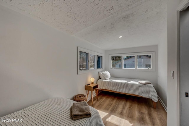 bedroom featuring light hardwood / wood-style floors and a textured ceiling