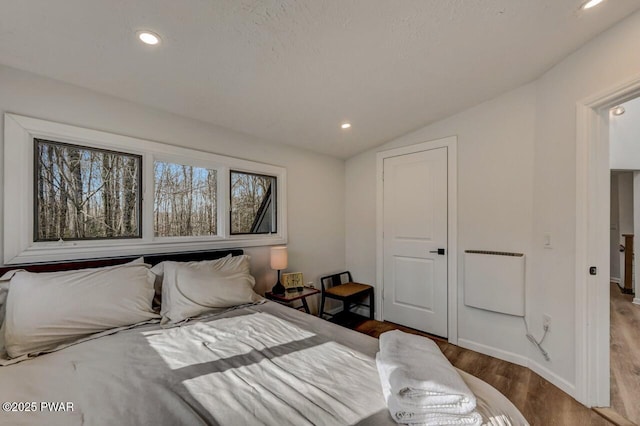 bedroom with hardwood / wood-style flooring and lofted ceiling