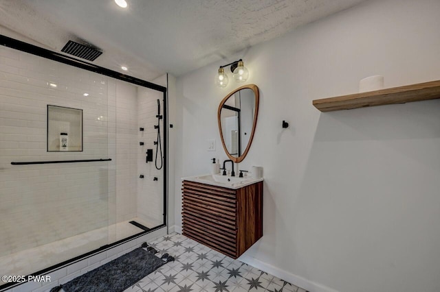 bathroom featuring vanity, a textured ceiling, and walk in shower