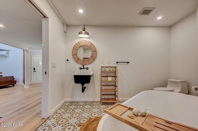 bathroom featuring wood-type flooring, toilet, and a bathtub