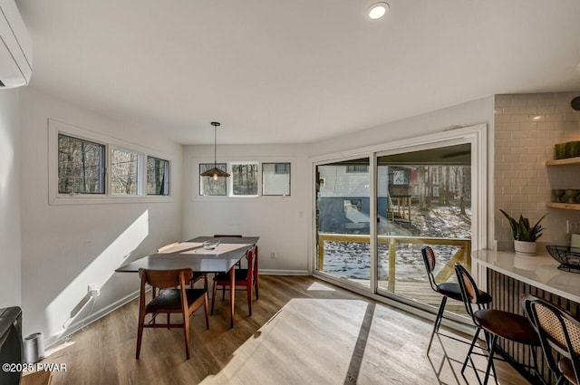 dining room with wood-type flooring and a wall mounted air conditioner