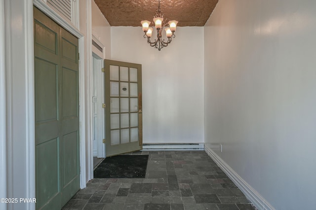 doorway to outside with an inviting chandelier and baseboard heating