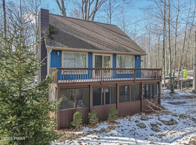 view of front of house featuring a chimney and a shingled roof