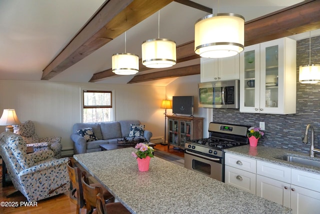 108 Juniper St, Dingmans Ferry, PA 18328 - kitchen featuring appliances with stainless steel finishes, decorative backsplash, light stone counters, wood finished floors, and beamed ceiling