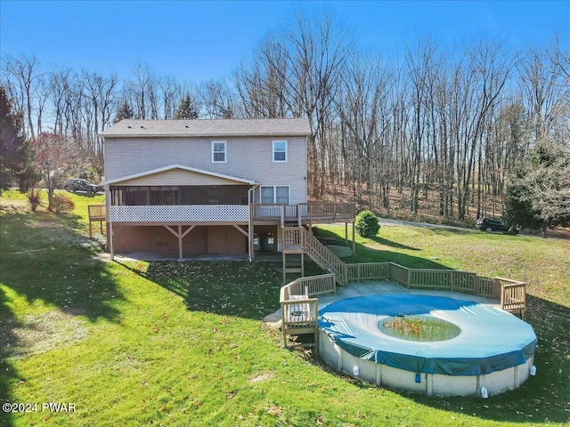 rear view of property featuring a yard, a wooden deck, and a sunroom