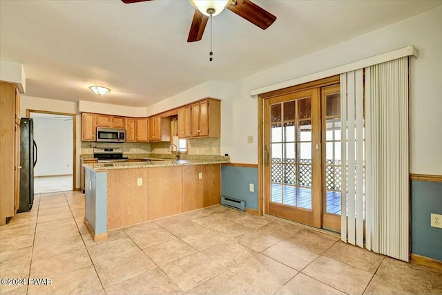 kitchen featuring kitchen peninsula, appliances with stainless steel finishes, ceiling fan, a baseboard radiator, and plenty of natural light