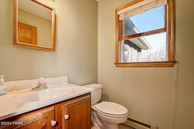 bathroom featuring vanity, toilet, and baseboard heating