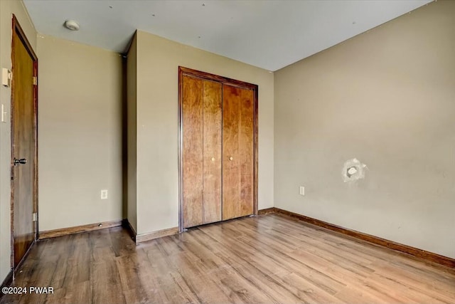 unfurnished bedroom with a closet and light hardwood / wood-style floors