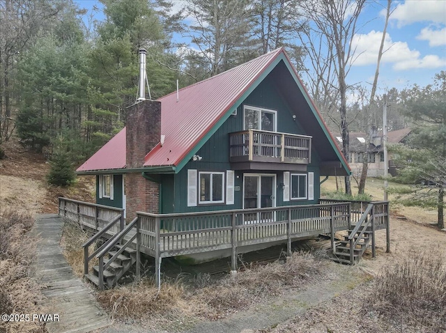 back of house with a balcony and a wooden deck