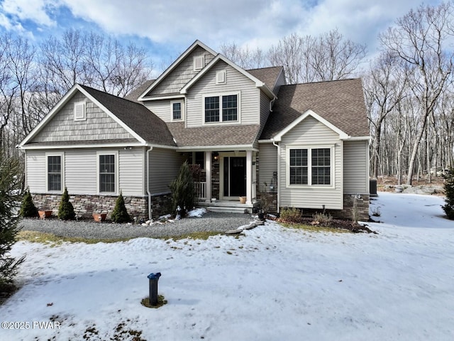 view of front of house featuring stone siding and a shingled roof