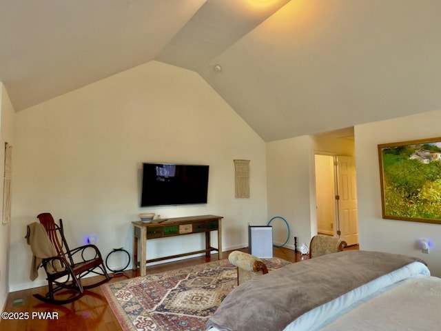 bedroom with vaulted ceiling, baseboards, and wood finished floors