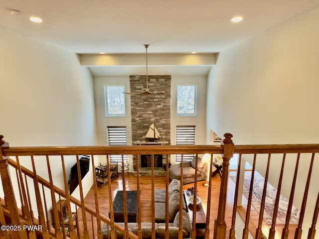 interior space featuring a stone fireplace, wood finished floors, and recessed lighting