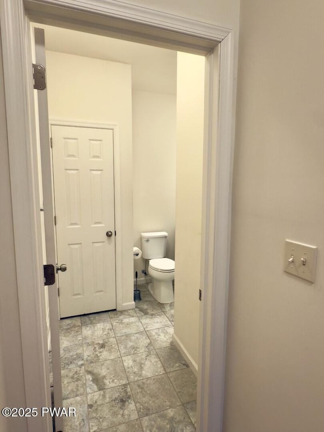 bathroom with baseboards and toilet