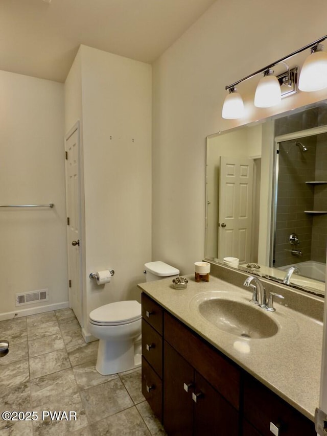 bathroom with toilet, vanity, visible vents, baseboards, and a shower with door