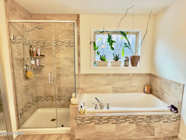 full bathroom featuring a stall shower and a garden tub