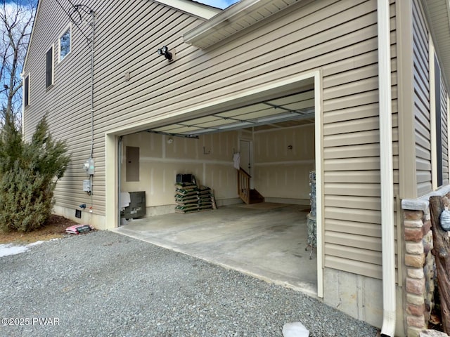 garage with driveway and electric panel