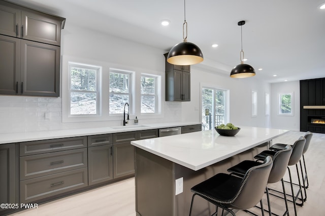 131 Song Mountain Dr, Tafton, PA 18464 - kitchen featuring backsplash, recessed lighting, gray cabinetry, stainless steel dishwasher, and a kitchen breakfast bar