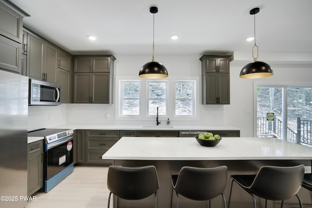 131 Song Mountain Dr, Tafton, PA 18464 - kitchen with stainless steel appliances, gray cabinets, light stone counters, a kitchen breakfast bar, and light wood-style flooring