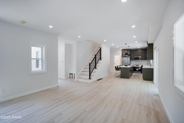 131 Song Mountain Dr, Tafton, PA 18464 - unfurnished living room with stairs, light wood-style flooring, and recessed lighting