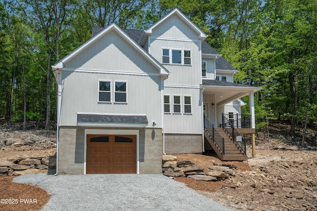 131 Song Mountain Dr, Tafton, PA 18464 - view of front facade featuring roof with shingles, an attached garage, driveway, and covered porch