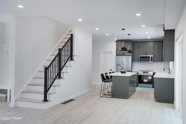 131 Song Mountain Dr, Tafton, PA 18464 - kitchen featuring appliances with stainless steel finishes, a breakfast bar, a kitchen island, light wood-style floors, and recessed lighting