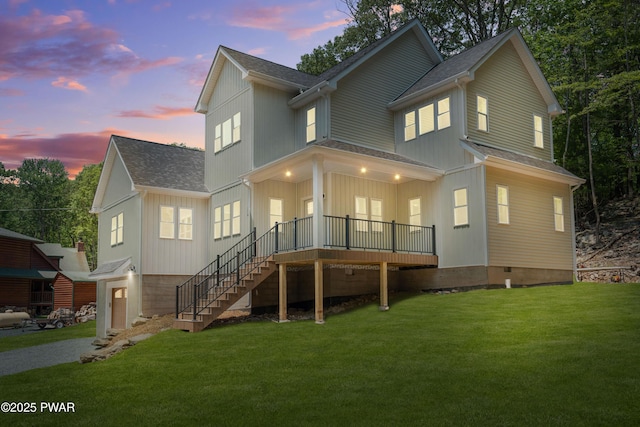 131 Song Mountain Dr, Tafton, PA 18464 - back of house at dusk featuring roof with shingles, a yard, stairway, an attached garage, and driveway