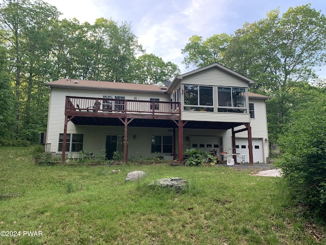 back of house with a yard, a garage, a wooden deck, and a sunroom