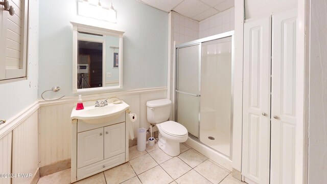 bathroom featuring a drop ceiling, vanity, an enclosed shower, and toilet