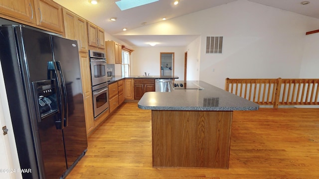 kitchen featuring kitchen peninsula, lofted ceiling with skylight, sink, and black appliances