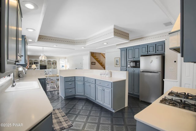 kitchen featuring black microwave, crown molding, a sink, freestanding refrigerator, and wallpapered walls