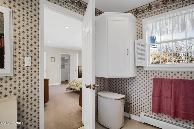 bathroom featuring a baseboard heating unit, baseboards, and wallpapered walls